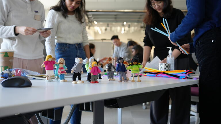 Small figures of people lined up on a studio desk