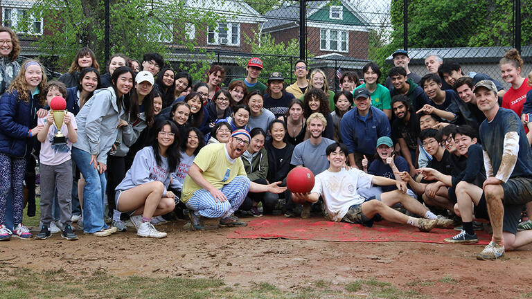 Design faculty and students in the mud celebrating a kickball event