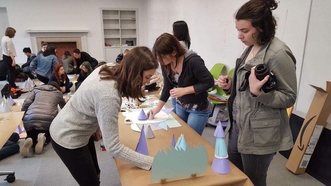 Students putting together a paper landscape.
