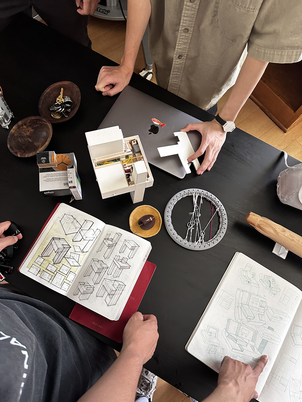 Photograph of student work and sketchbooks on a table.