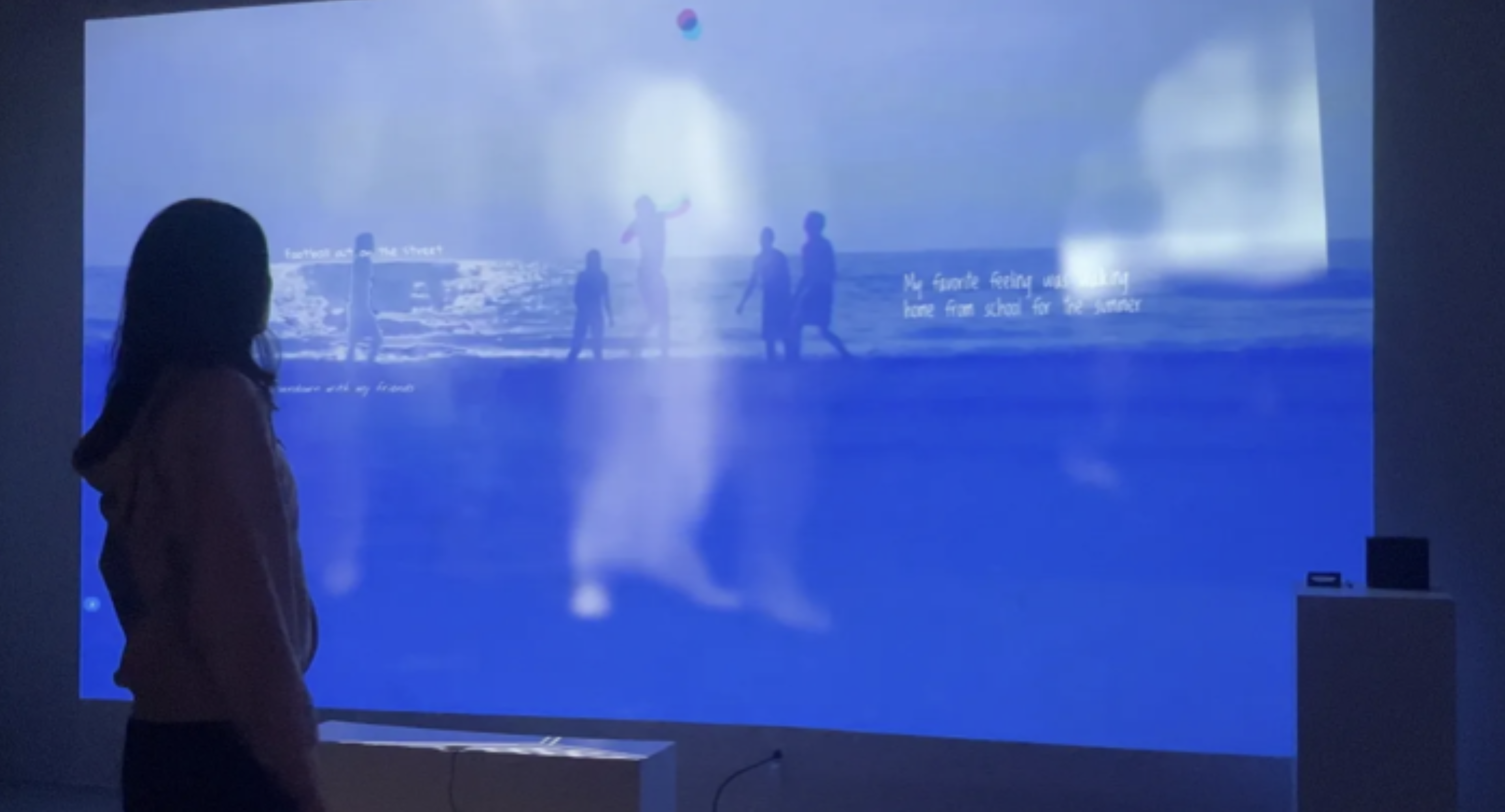 A woman standing infant of an image projected on a wall