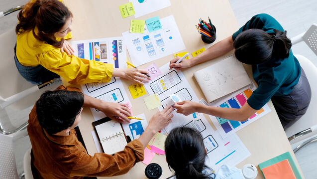 An overhead shot of a team of designers working at a table