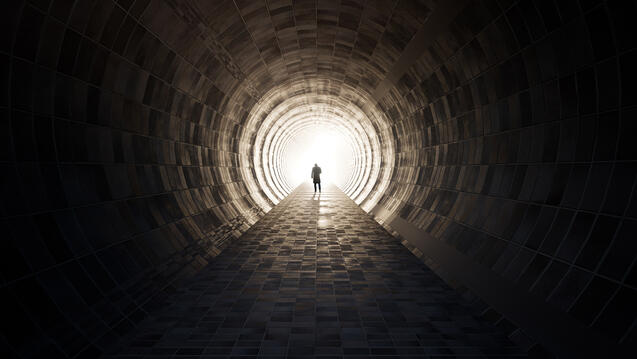 A man walking down a very long tunnel