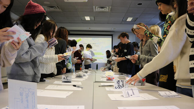 Two rows of students looking at Zines they made