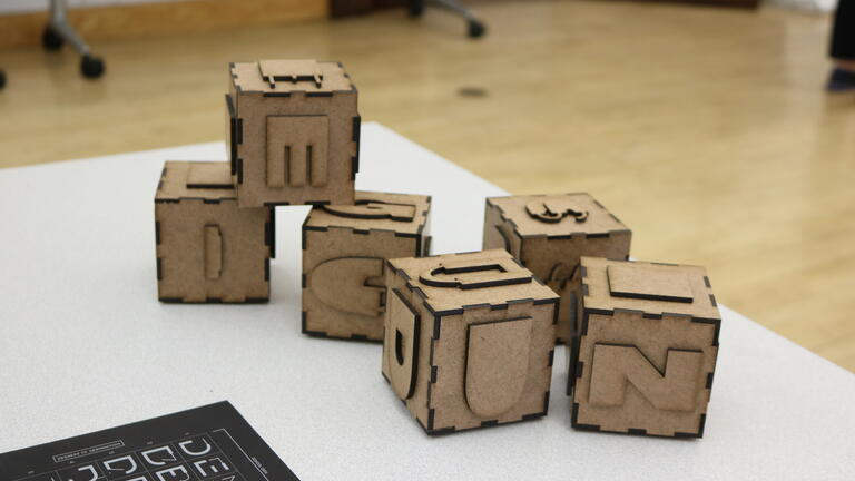 Laser cut blocks that spell out the word design.