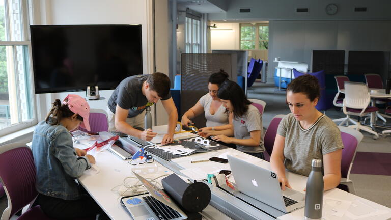 Master's Students working at a table in the grad studio.