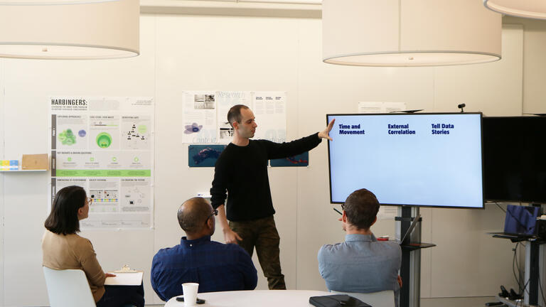 A grad student giving a presentation in the Grad Studio