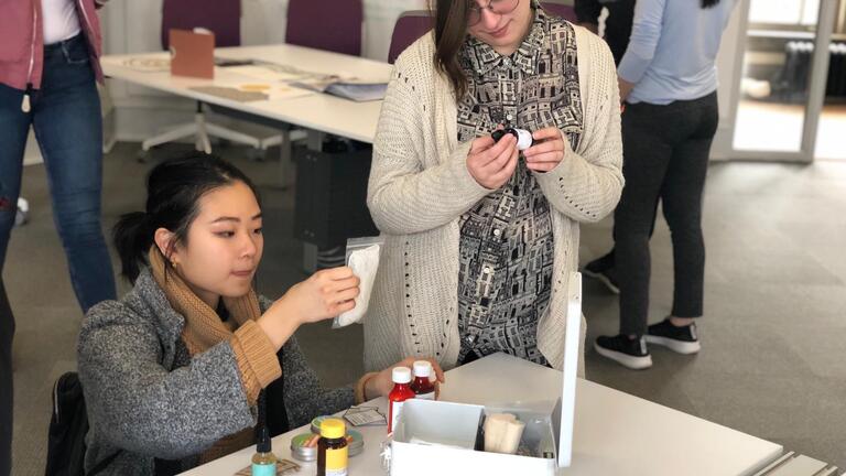 Two women looking at the contents of a first aid kit.