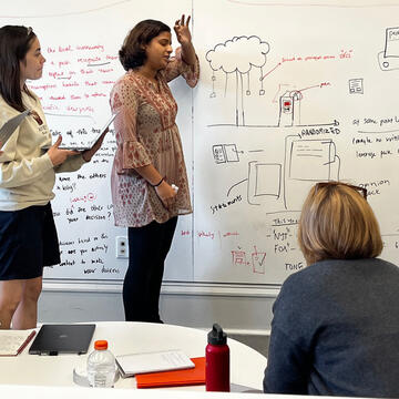 Master's Students in front of a whiteboard