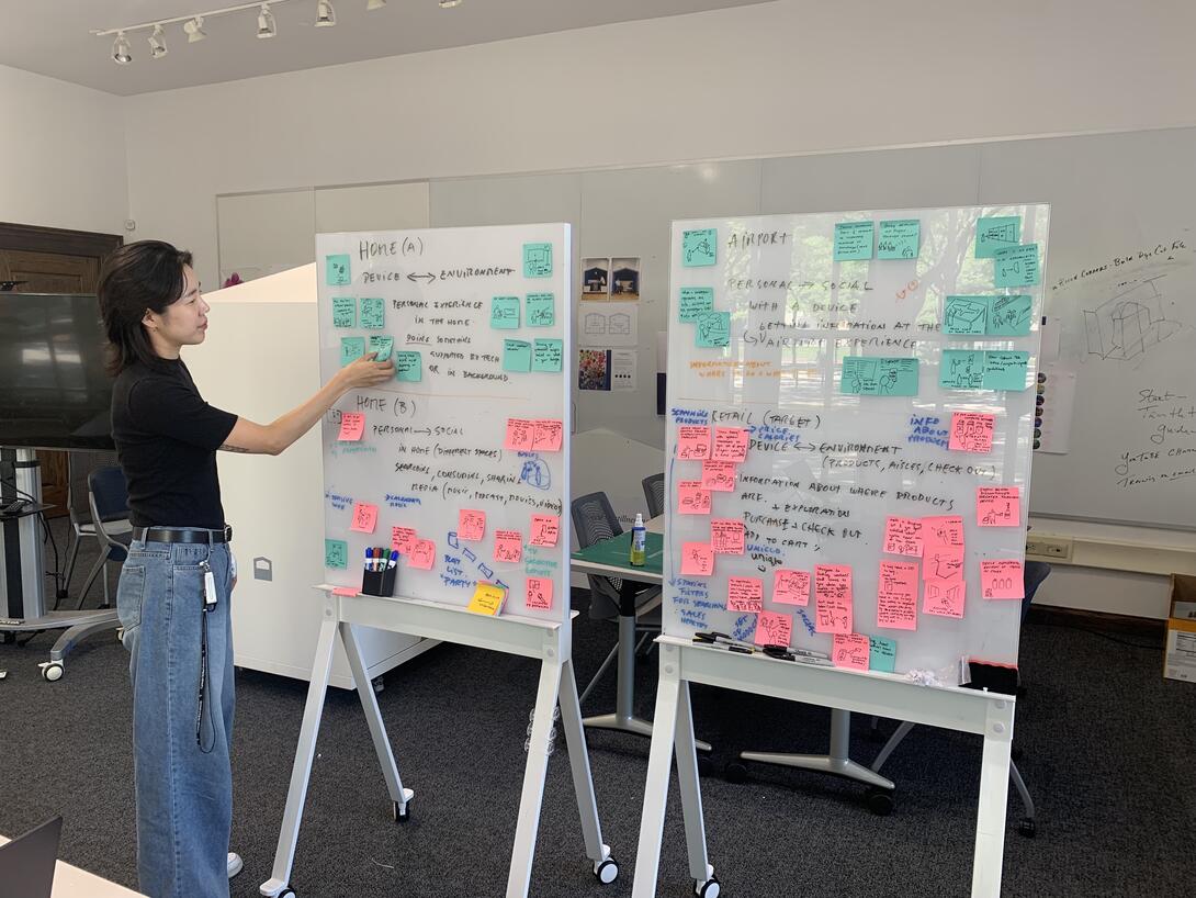 A student adding post it notes to a board
